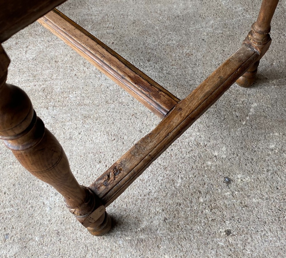 An 18th-century French fruitwood occasional table featuring a rectangular top, single drawer with an iron ring handle, turned legs, and a low stretcher base. View V