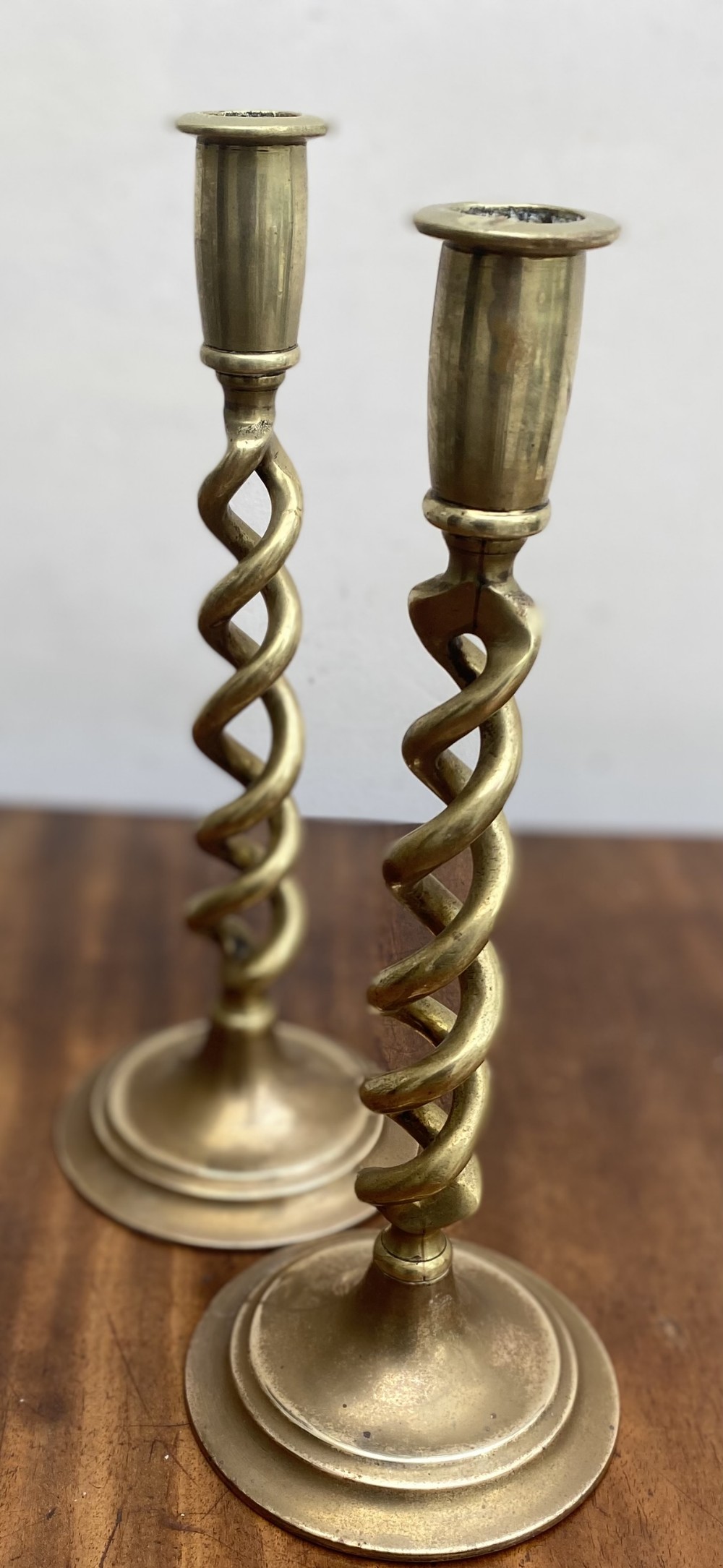 A pair of Victorian solid brass candlesticks featuring open barley twist stems and stepped circular bases.