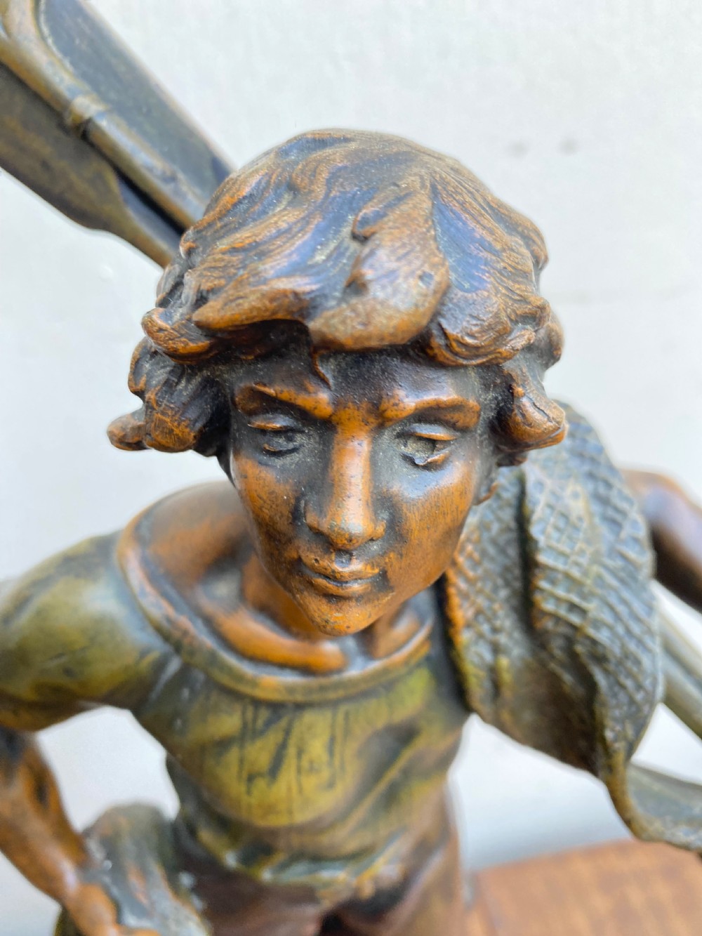 A pair of patinated spelter figures depicting a fisherwoman holding a basket and a fisherman carrying nets, mounted on circular turned wood bases with brass title plates. View VII