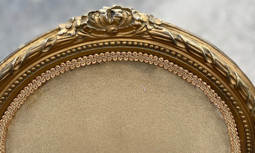 A set of four 19th-century French Louis XVI style side chairs featuring carved gilded wooden frames with oval medallion backs and beige velvet upholstery. View IV