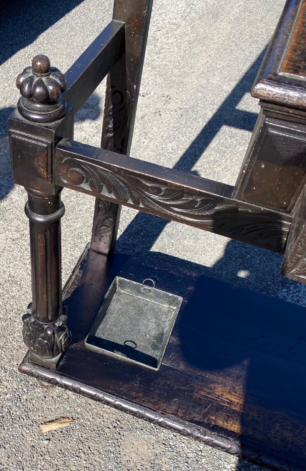 A dark carved oak Victorian hall stand featuring a central rectangular mirror, lion mask carvings, turned coat pegs, umbrella holders, and metal drip trays. View IX