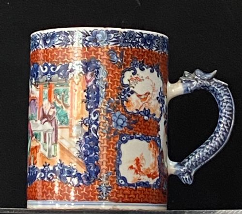 fig 1. An 18th-century cylindrical Chinese export porcelain tankard decorated with Mandarin figures, panels of birds, iron-red lattice background, and a sculpted blue dragon handle.