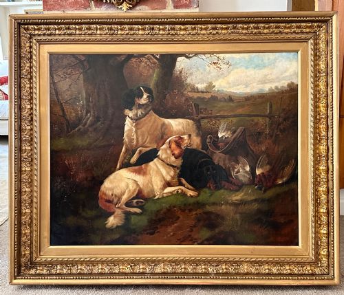 fig 3. An oil painting on canvas depicting gun dogs lying beside harvested game birds in a rural landscape, framed in an ornate gold leaf frame.