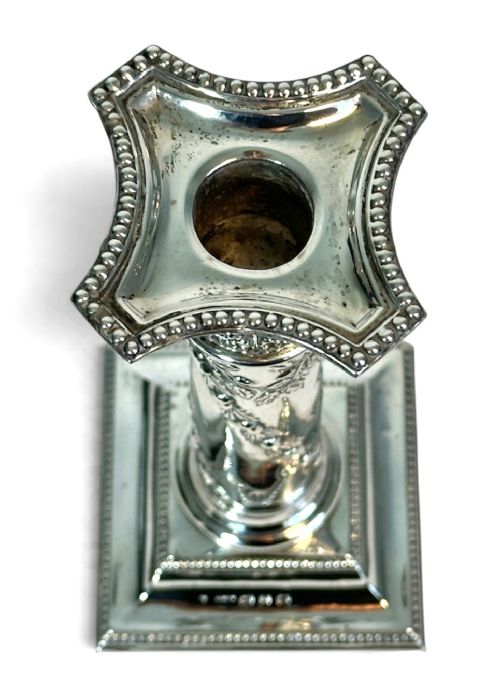 A pair of polished silver column candlesticks featuring Corinthian capitals, foliate swags, and stepped beaded bases. View VI