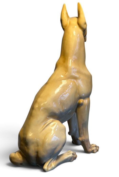 fig 2. A glazed fawn-coloured Nymphenburg porcelain figurine depicting a seated Great Dane with erect ears and a black muzzle.
