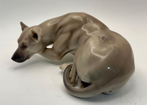 fig 1. A glazed Nymphenburg porcelain figurine depicting a recumbent Great Dane dog in taupe grey and neutral tones.