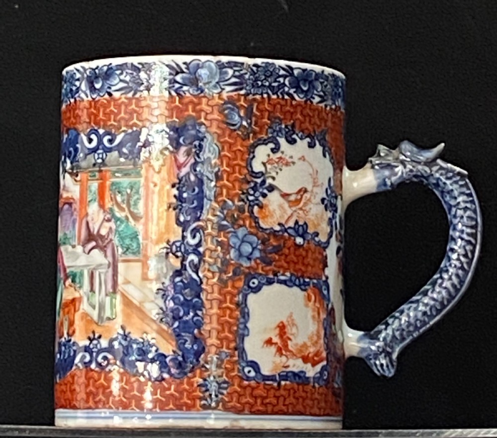 An 18th-century cylindrical Chinese export porcelain tankard decorated with Mandarin figures, panels of birds, iron-red lattice background, and a sculpted blue dragon handle. View II