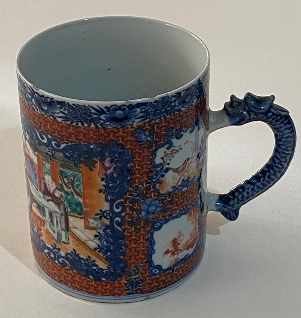 An 18th-century cylindrical Chinese export porcelain tankard decorated with Mandarin figures, panels of birds, iron-red lattice background, and a sculpted blue dragon handle. View III