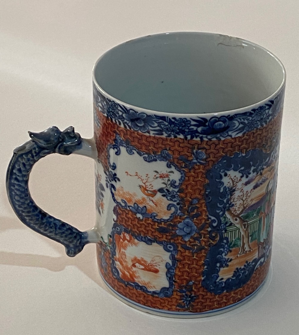 An 18th-century cylindrical Chinese export porcelain tankard decorated with Mandarin figures, panels of birds, iron-red lattice background, and a sculpted blue dragon handle. View IV
