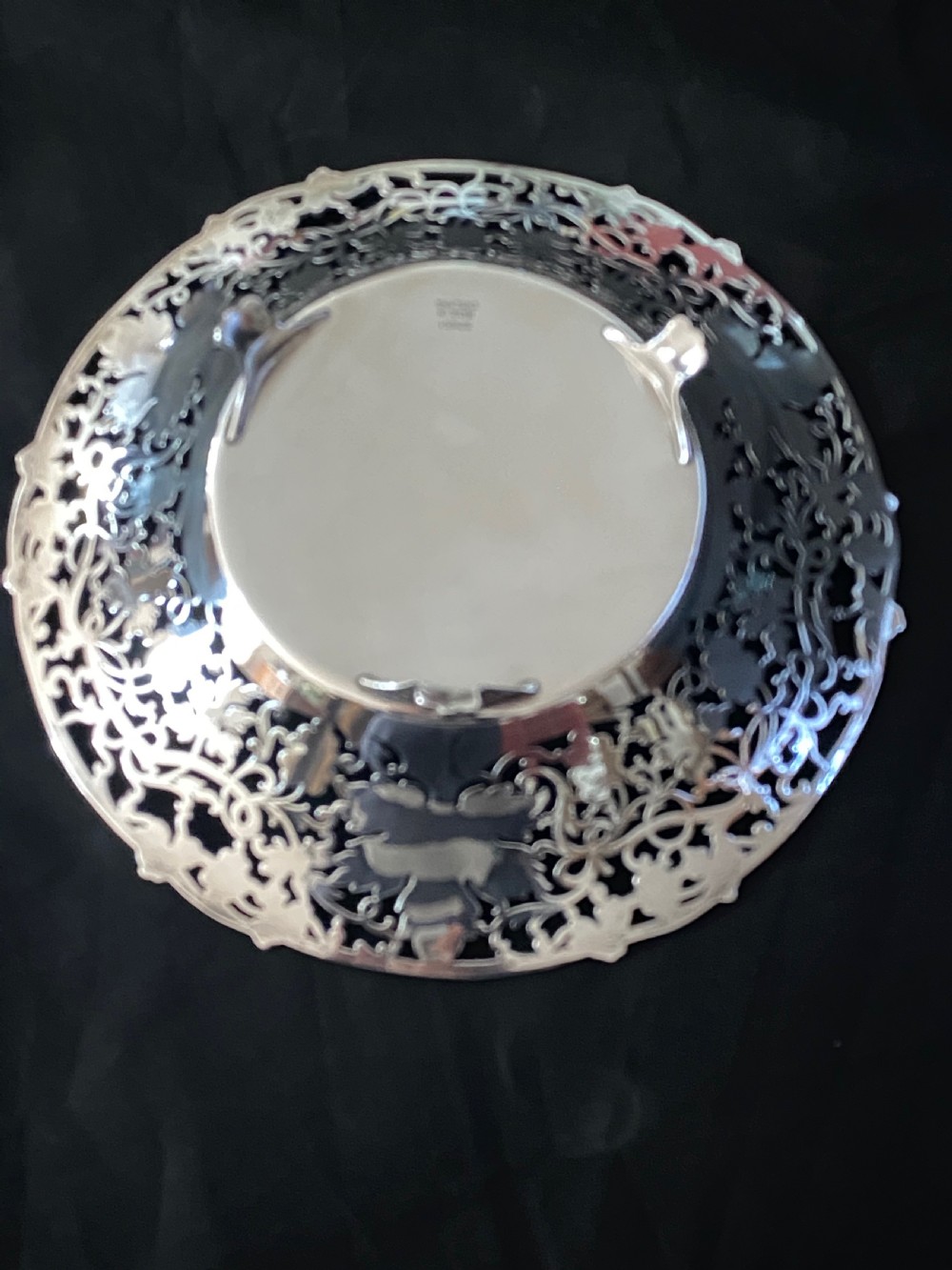 A circular antique silver footed bowl featuring an intricate pierced fretwork rim decorated with grapevine leaves and grape clusters surrounding a smooth polished centre. View IV