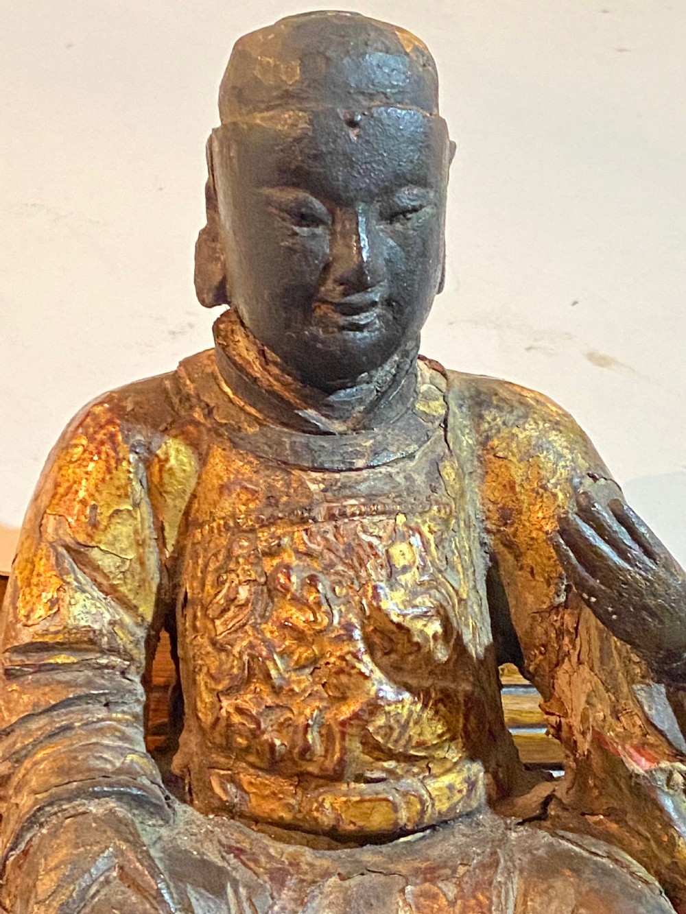 An eighteenth-century hand-carved wooden Chinese deity statue featuring worn gold leaf gilding and dark lacquer finish in a seated pose. View XIII