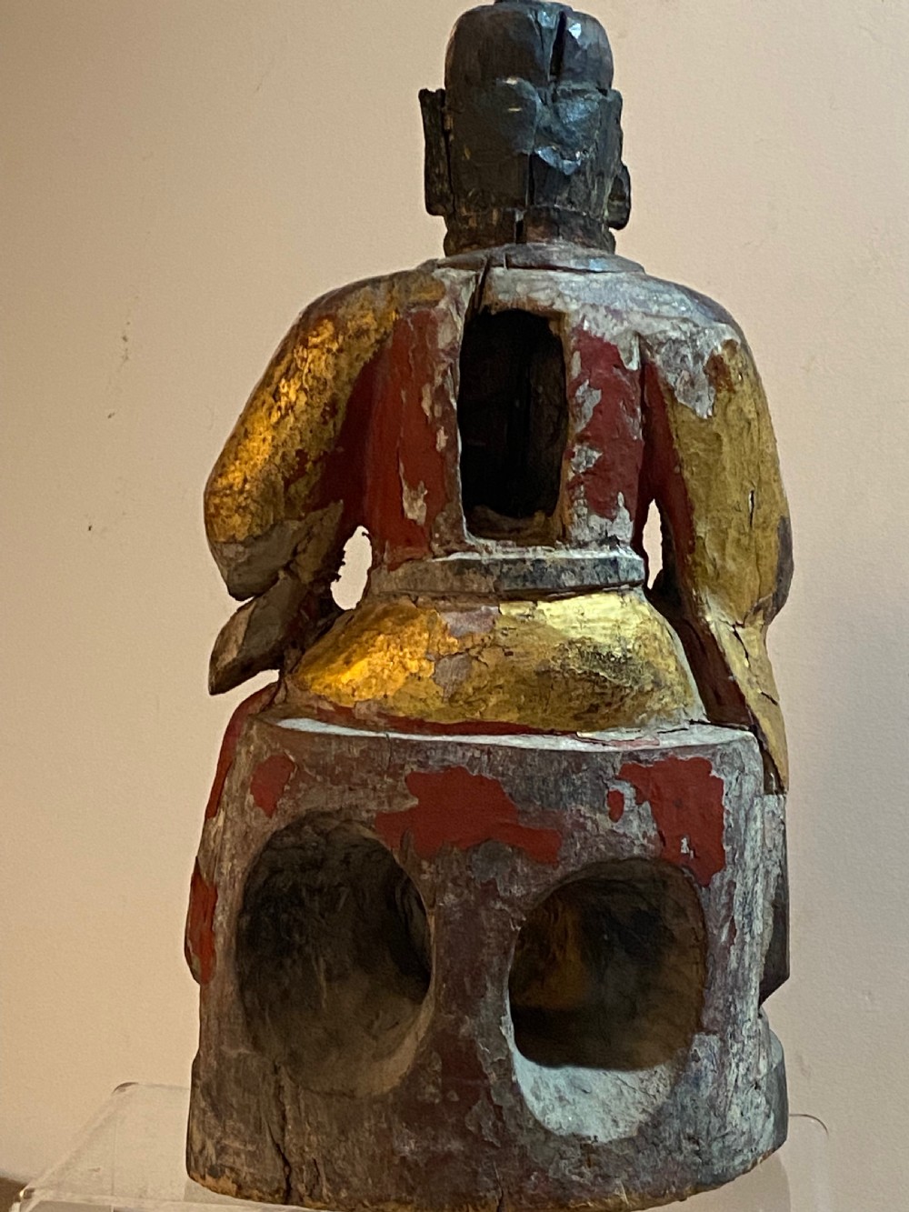 An eighteenth-century hand-carved wooden Chinese deity statue featuring worn gold leaf gilding and dark lacquer finish in a seated pose. View V