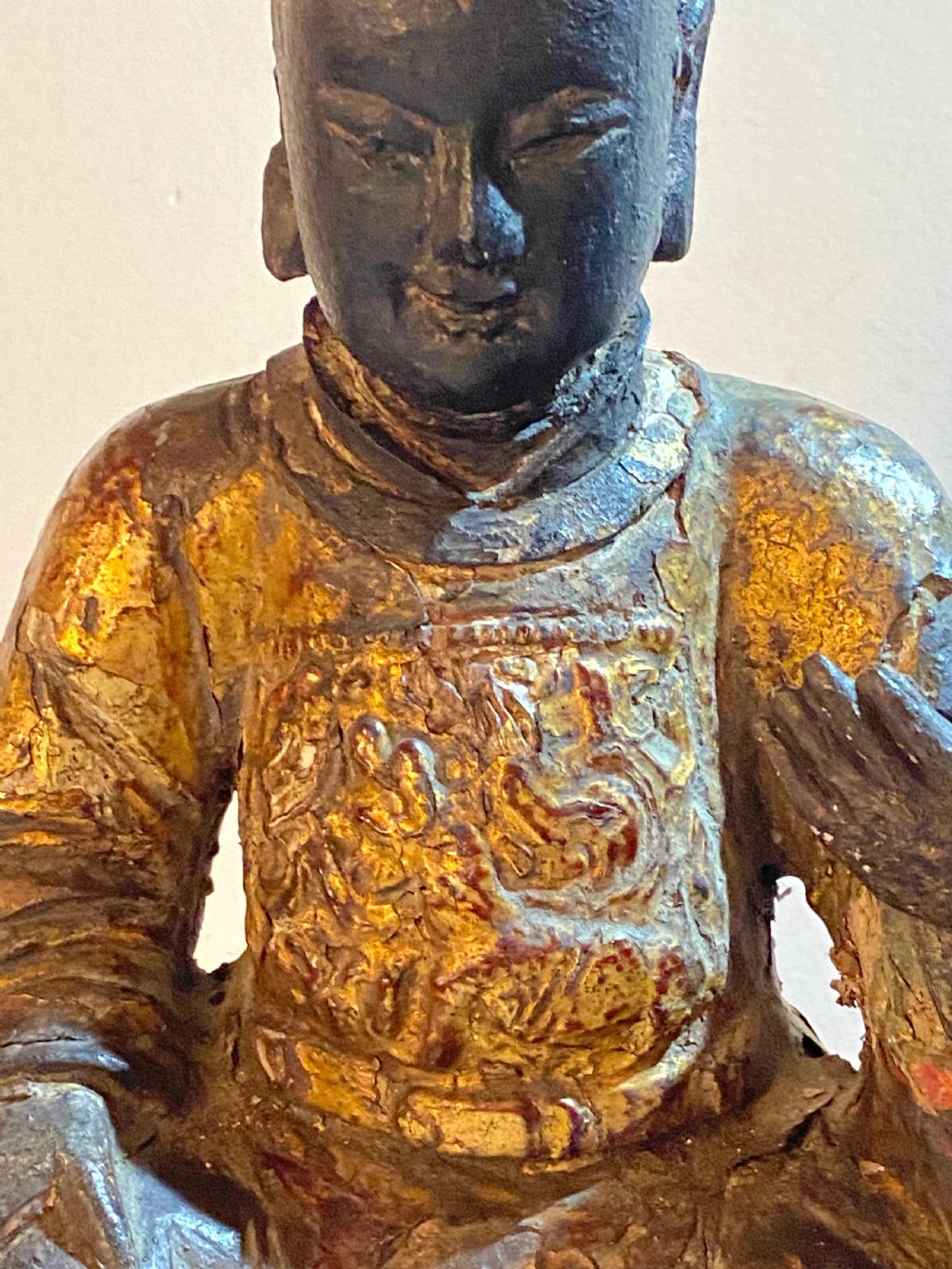 An eighteenth-century hand-carved wooden Chinese deity statue featuring worn gold leaf gilding and dark lacquer finish in a seated pose. View VI