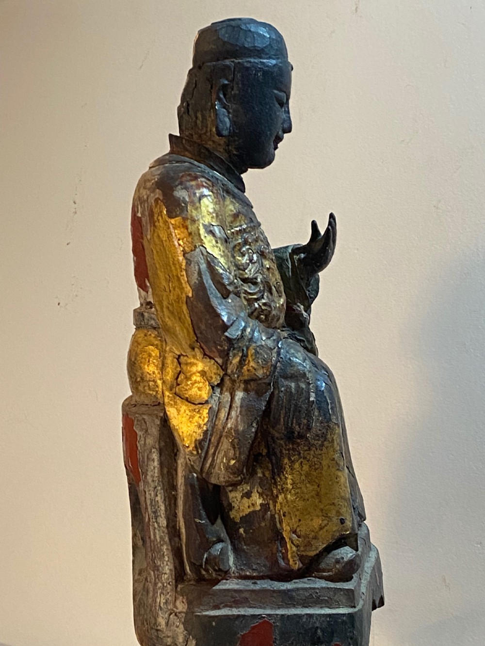 An eighteenth-century hand-carved wooden Chinese deity statue featuring worn gold leaf gilding and dark lacquer finish in a seated pose. View VII
