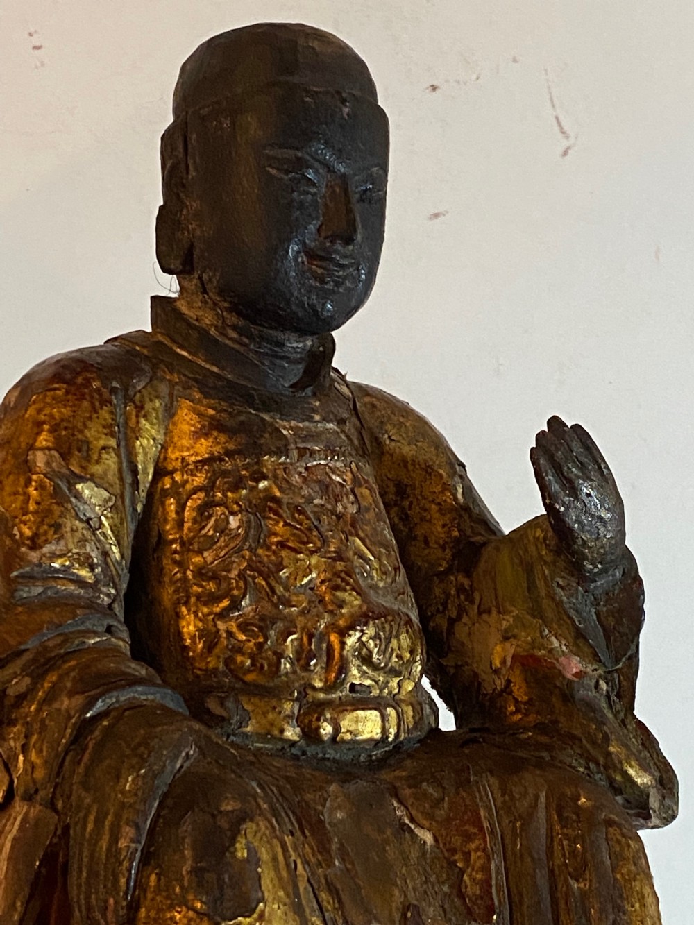 An eighteenth-century hand-carved wooden Chinese deity statue featuring worn gold leaf gilding and dark lacquer finish in a seated pose. View VIII