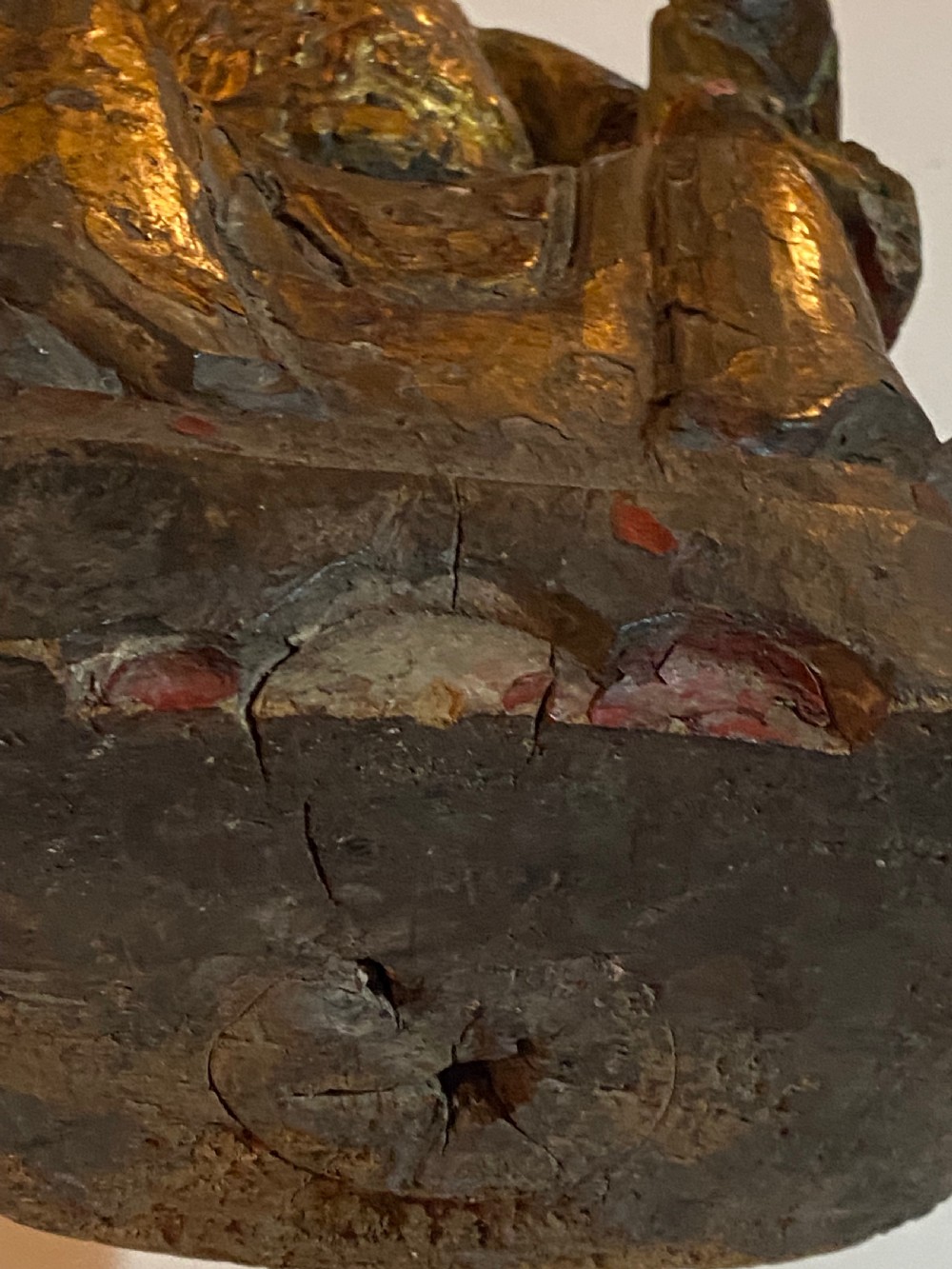 An eighteenth-century hand-carved wooden Chinese deity statue featuring worn gold leaf gilding and dark lacquer finish in a seated pose. View IX