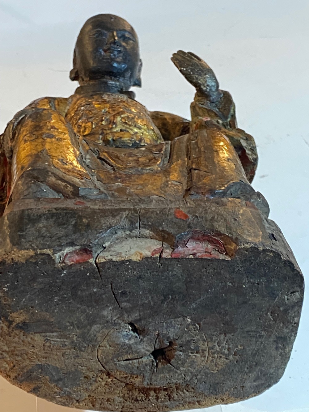 An eighteenth-century hand-carved wooden Chinese deity statue featuring worn gold leaf gilding and dark lacquer finish in a seated pose. View XI