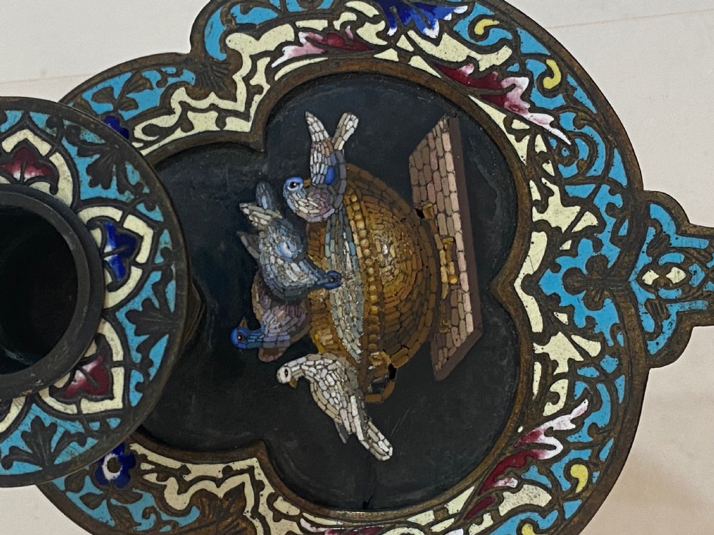 An antique metal chamberstick decorated with turquoise cloisonne enamel scrollwork surrounding a central micromosaic panel of birds drinking from a bowl. View IX