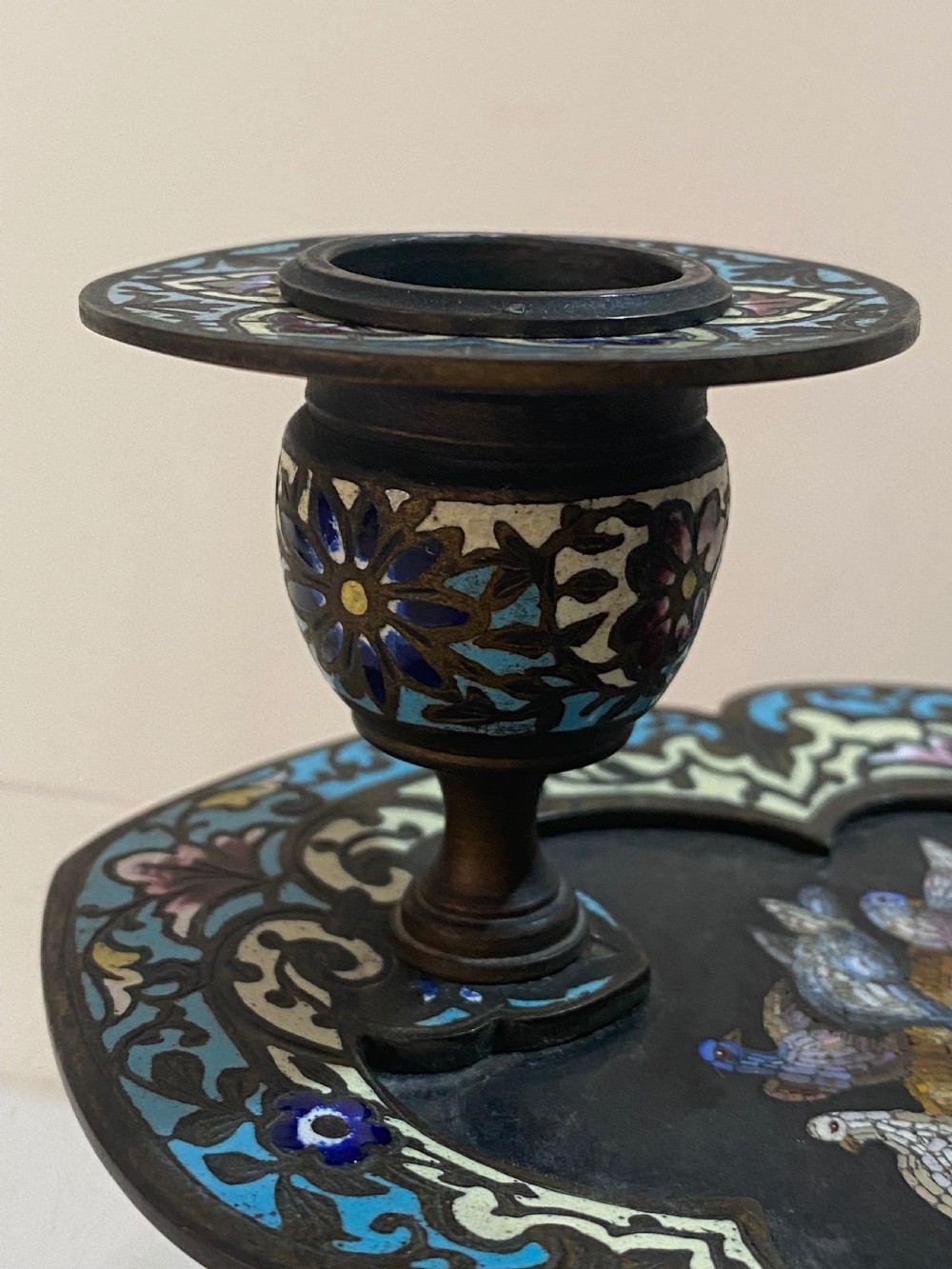 An antique metal chamberstick decorated with turquoise cloisonne enamel scrollwork surrounding a central micromosaic panel of birds drinking from a bowl. View XIII