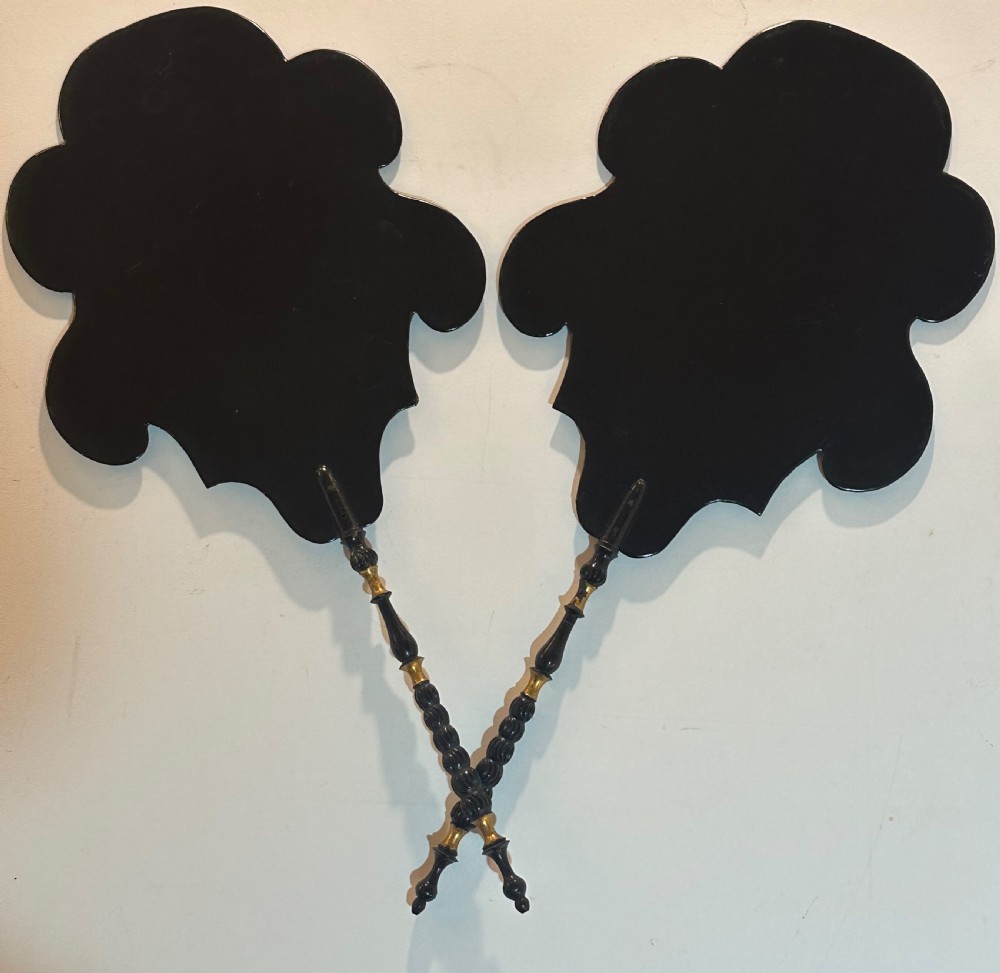A pair of black Victorian papier-mache face screens with scalloped edges, hand-painted floral motifs inlaid with mother-of-pearl, and turned ebonised handles. View IV