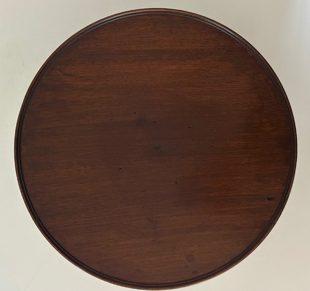A circular Georgian mahogany Lazy Susan with a raised lip edge set upon a turned pedestal stem and wide circular base. View IV