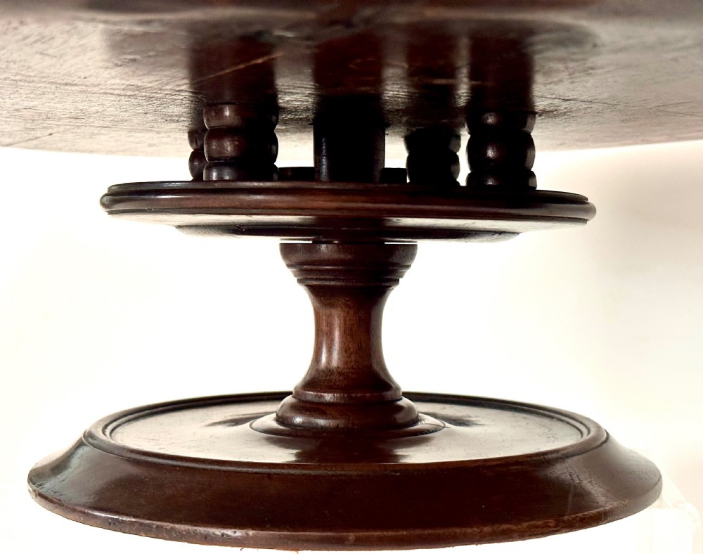 A circular Georgian mahogany Lazy Susan with a raised lip edge set upon a turned pedestal stem and wide circular base. View VI