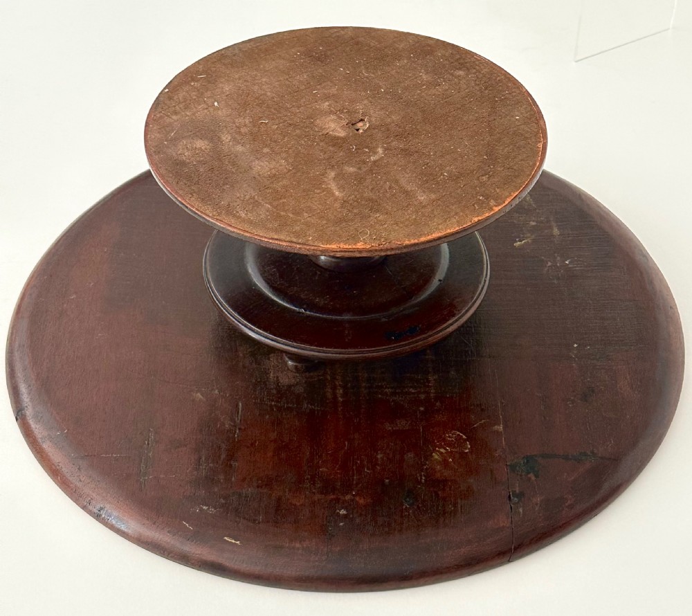 A circular Georgian mahogany Lazy Susan with a raised lip edge set upon a turned pedestal stem and wide circular base. View VIII