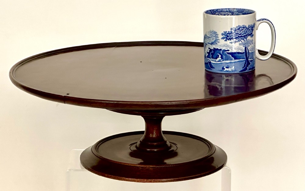 A circular Georgian mahogany Lazy Susan with a raised lip edge set upon a turned pedestal stem and wide circular base. View IX