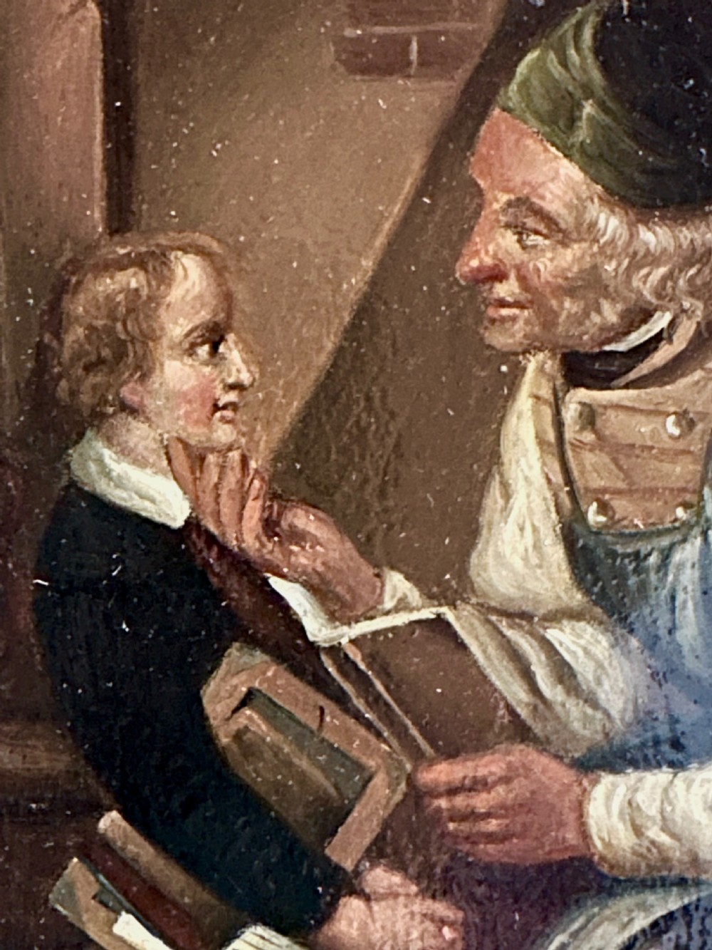 A pair of framed 19th-century oil paintings on tin depicting domestic interior genre scenes, mounted within broad maple veneer frames with gilded inner slips. View VI
