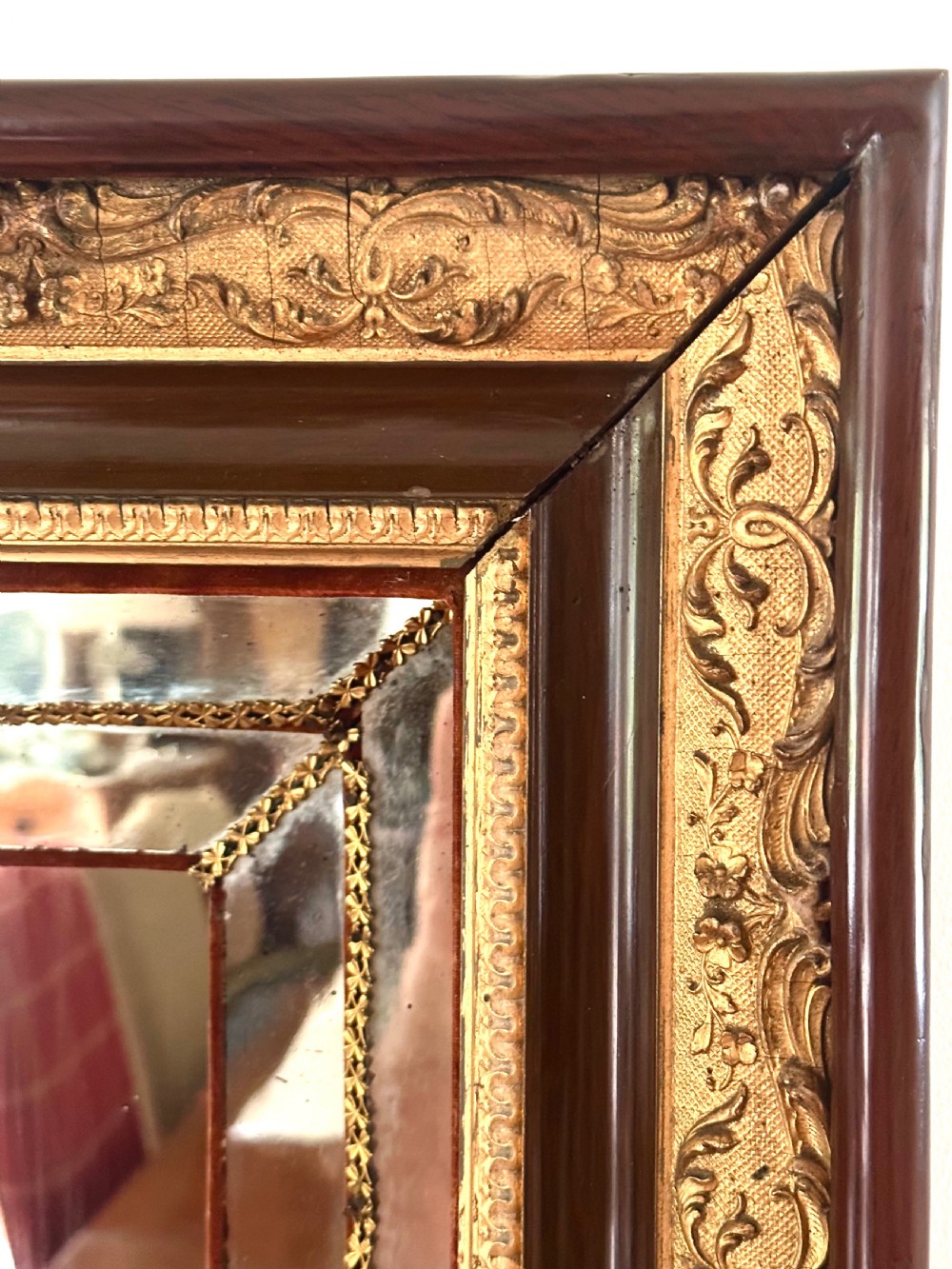 A rectangular nineteenth-century Italian wall mirror featuring a moulded dark wood and gilded carved frame surrounding marginal mirrored glass panels. View V