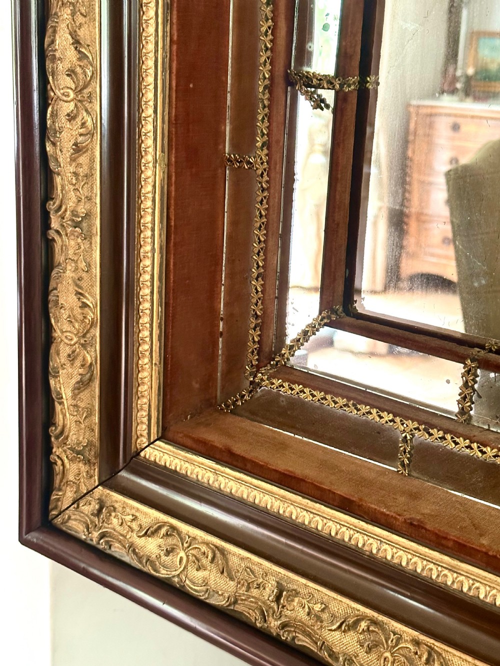 A rectangular nineteenth-century Italian wall mirror featuring a moulded dark wood and gilded carved frame surrounding marginal mirrored glass panels. View VI
