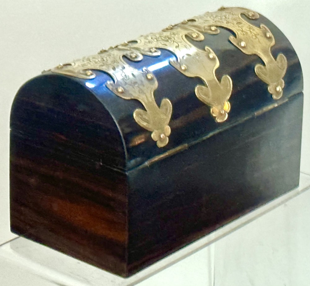 A dark coromandel wood stationery box featuring a domed lid decorated with engraved brass strapwork mounts and a central keyhole. View III