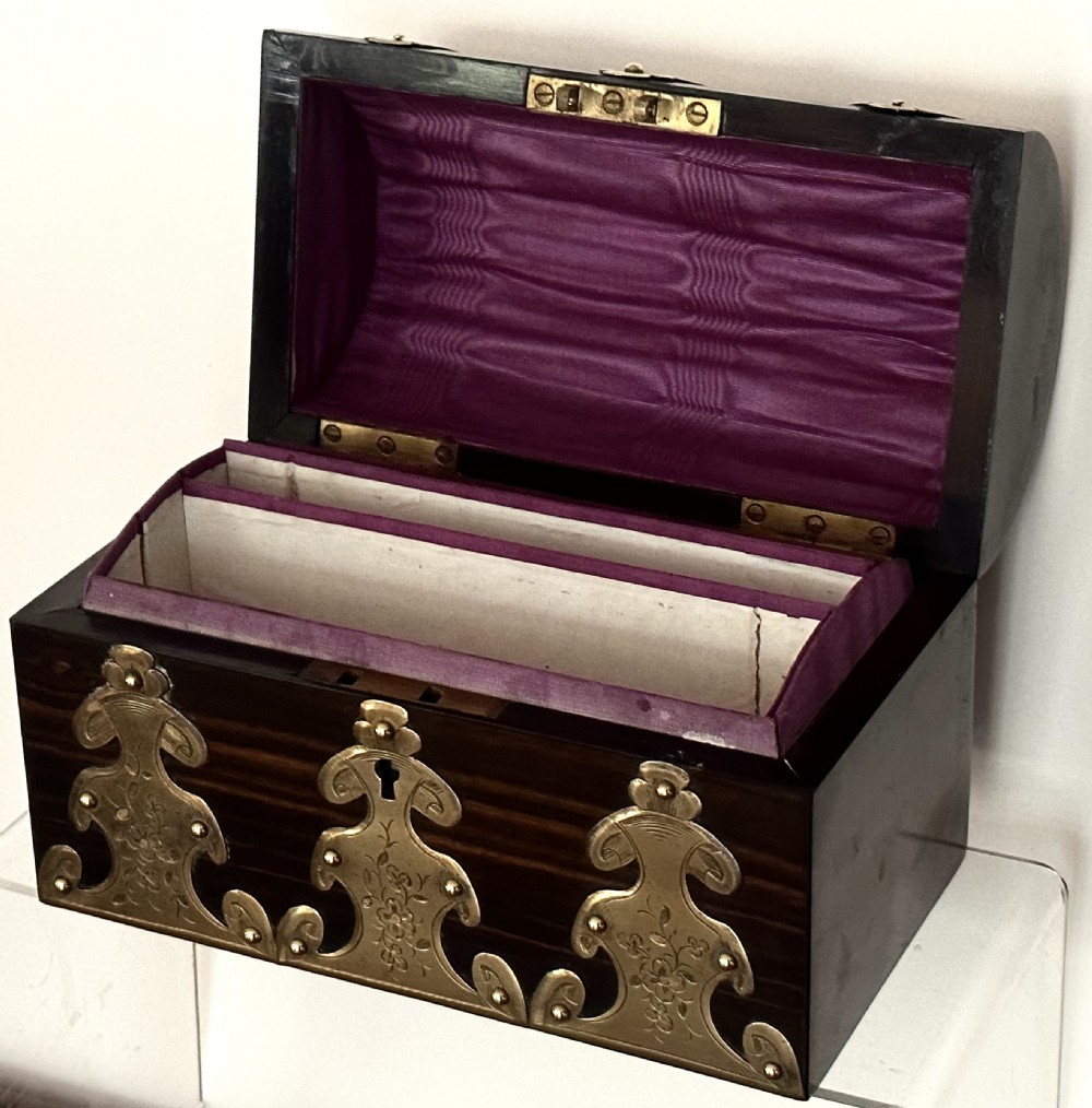A dark coromandel wood stationery box featuring a domed lid decorated with engraved brass strapwork mounts and a central keyhole. View IV