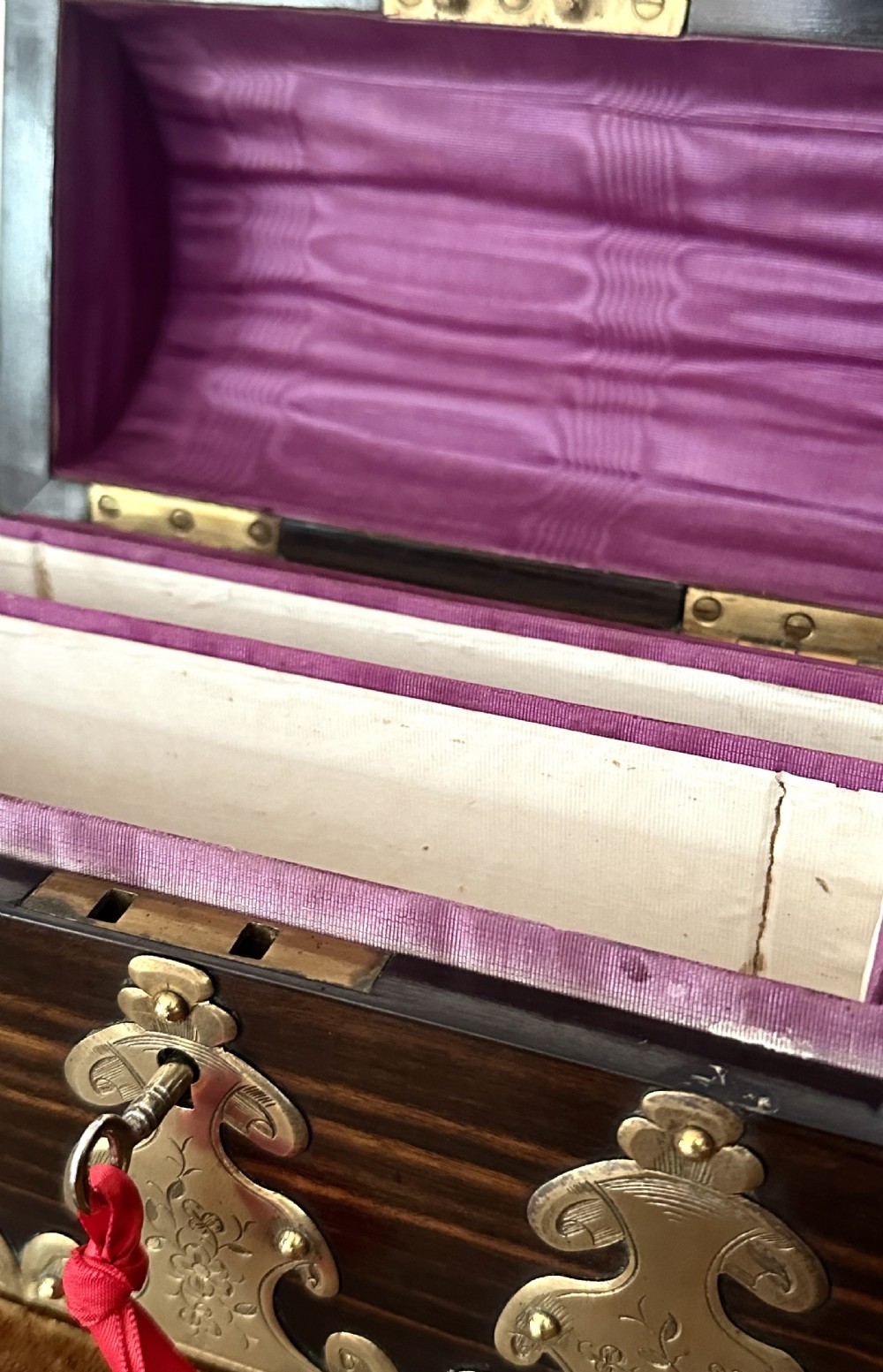 A dark coromandel wood stationery box featuring a domed lid decorated with engraved brass strapwork mounts and a central keyhole. View VII