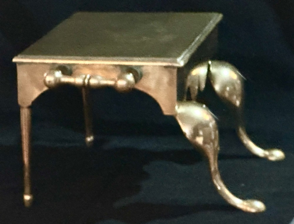 A Georgian brass fireplace footman featuring a rectangular top, shaped front apron, turned side handles, and cabriole front legs. View II