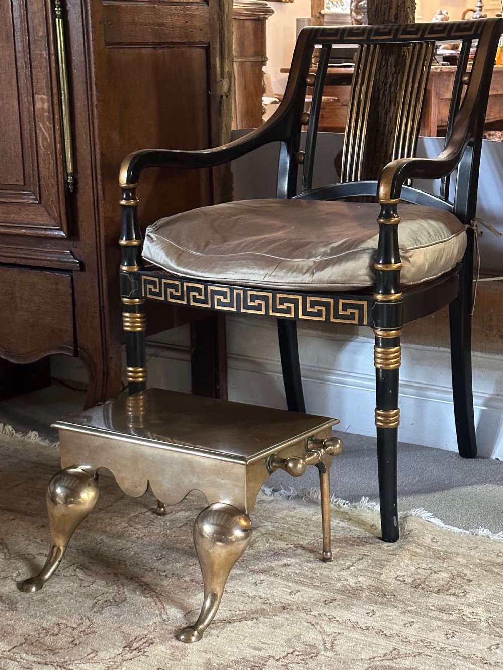 A Georgian brass fireplace footman featuring a rectangular top, shaped front apron, turned side handles, and cabriole front legs. View III
