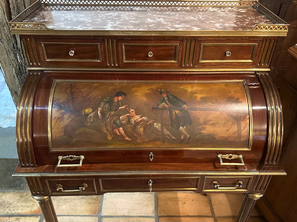 A mahogany French cylinder escritoire featuring a central painted pastoral scene on the roll-top, upper drawer tier, brass mounts, and slender fluted legs. View VII