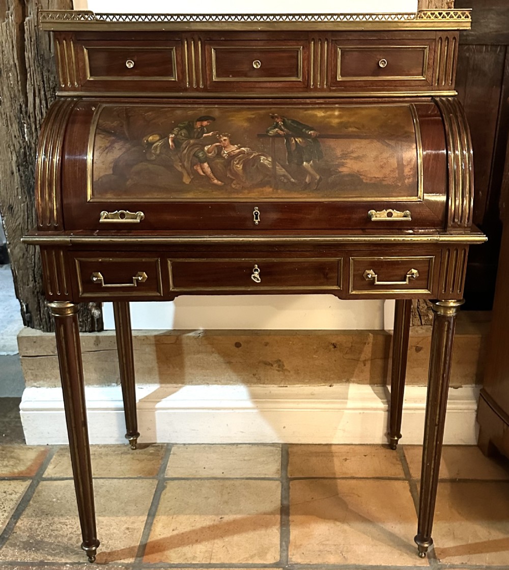 A mahogany French cylinder escritoire featuring a central painted pastoral scene on the roll-top, upper drawer tier, brass mounts, and slender fluted legs. View XIV