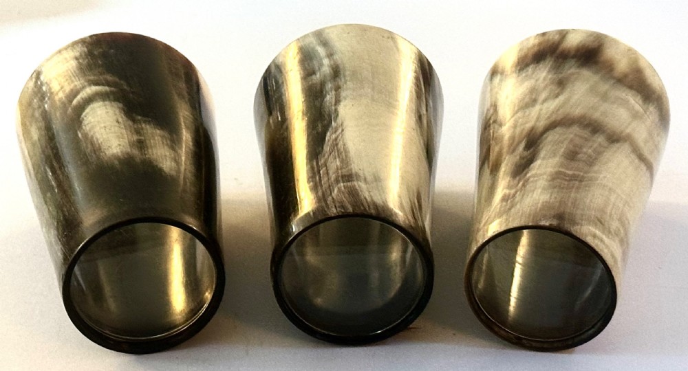 A set of three cylindrical antique drinking beakers made from polished natural horn with variegated cream, amber, and dark brown graining. View V