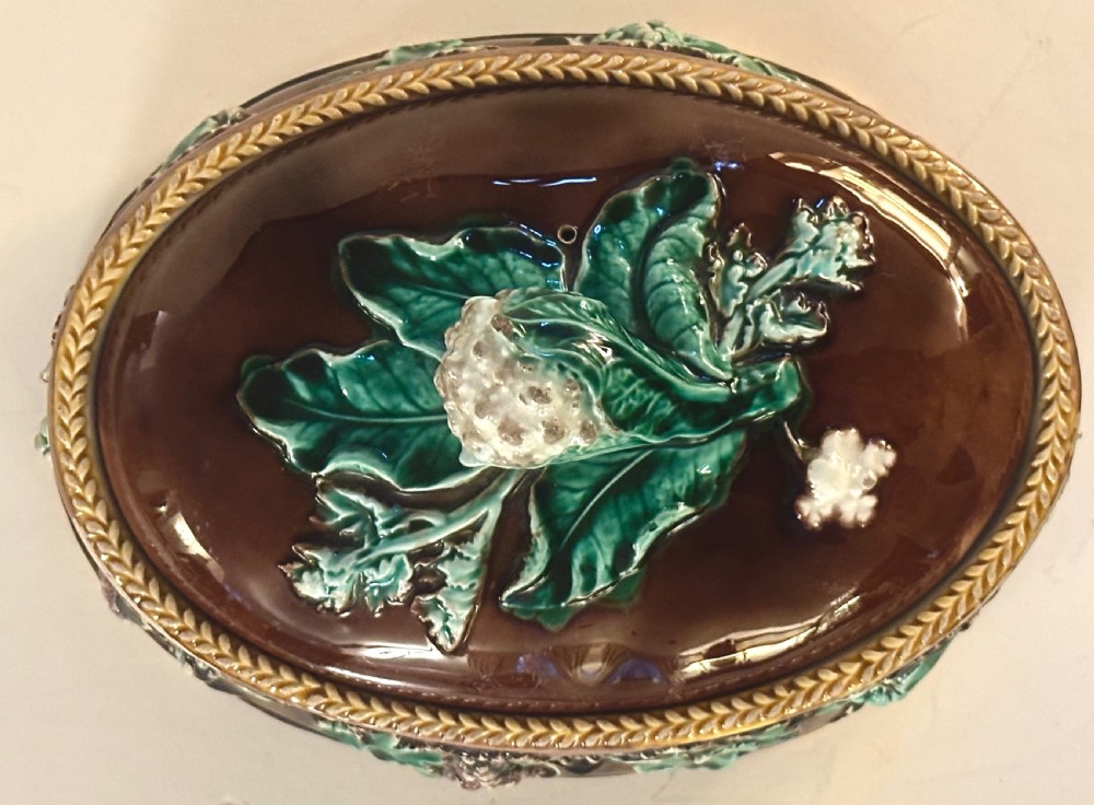 An oval dark brown glazed earthenware tureen featuring relief-moulded green vine leaves and a cauliflower finial on the lid. View III