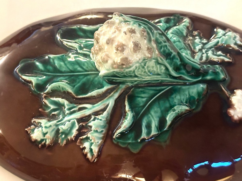 An oval dark brown glazed earthenware tureen featuring relief-moulded green vine leaves and a cauliflower finial on the lid. View VII