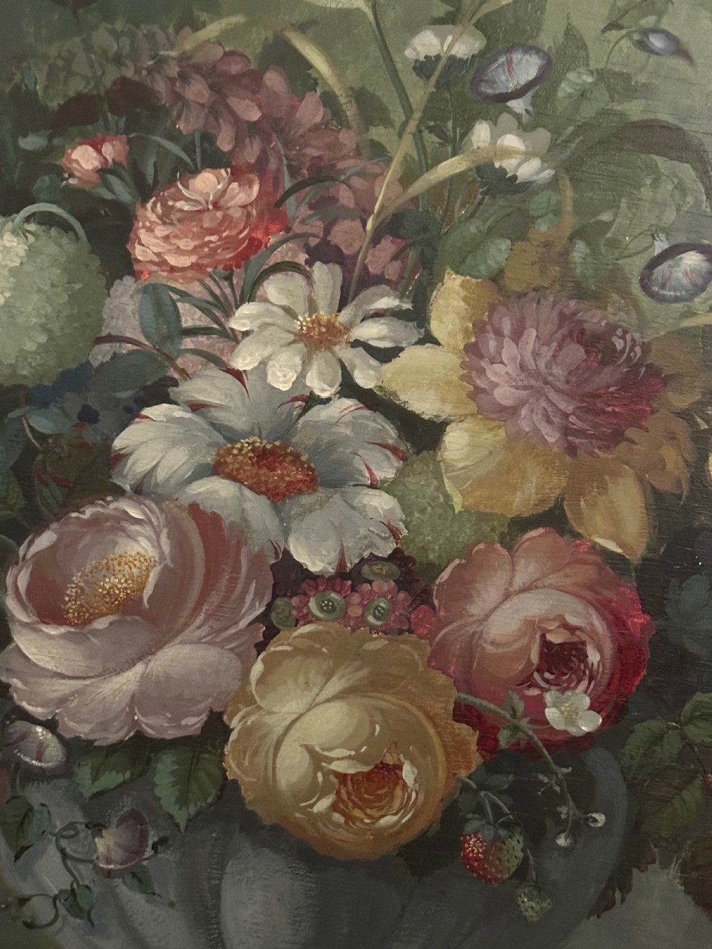 A framed classical floral still life painting depicting a colourful bouquet of flowers inside a stone urn set within an arched architectural niche. View II