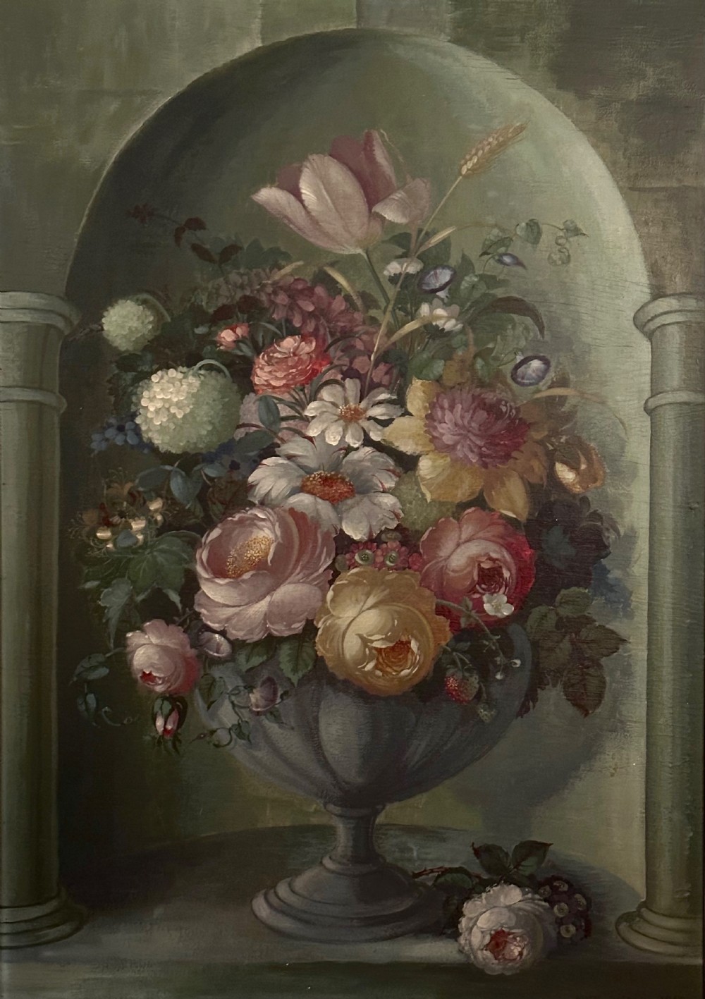 A framed classical floral still life painting depicting a colourful bouquet of flowers inside a stone urn set within an arched architectural niche. View III