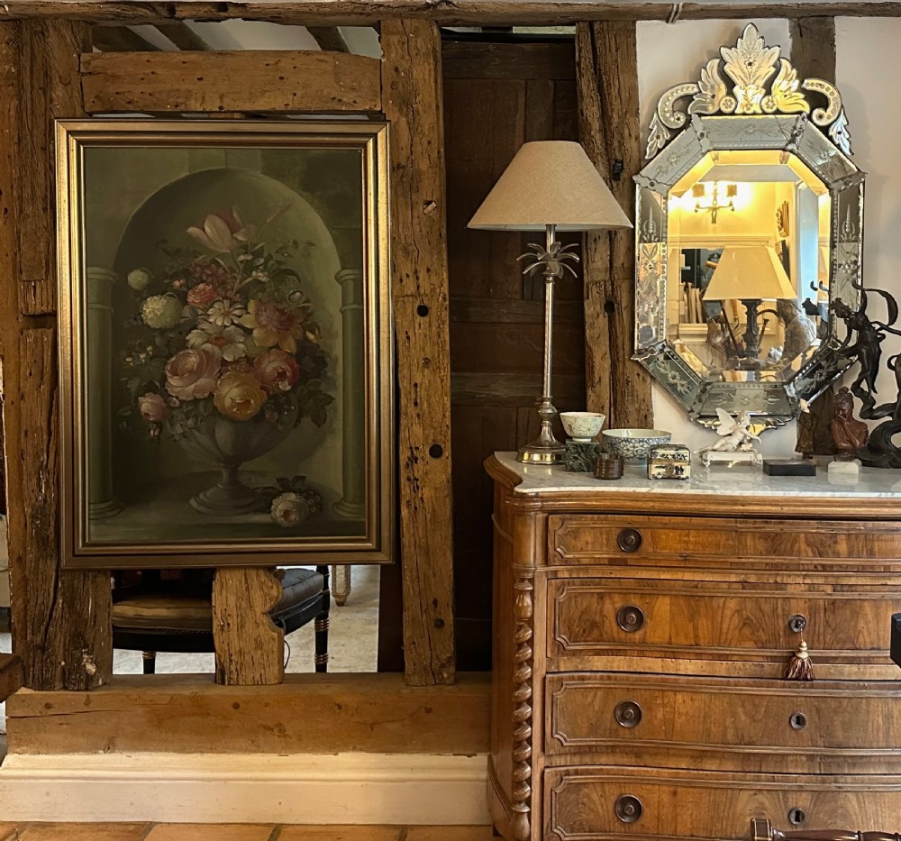 A framed classical floral still life painting depicting a colourful bouquet of flowers inside a stone urn set within an arched architectural niche. View VII