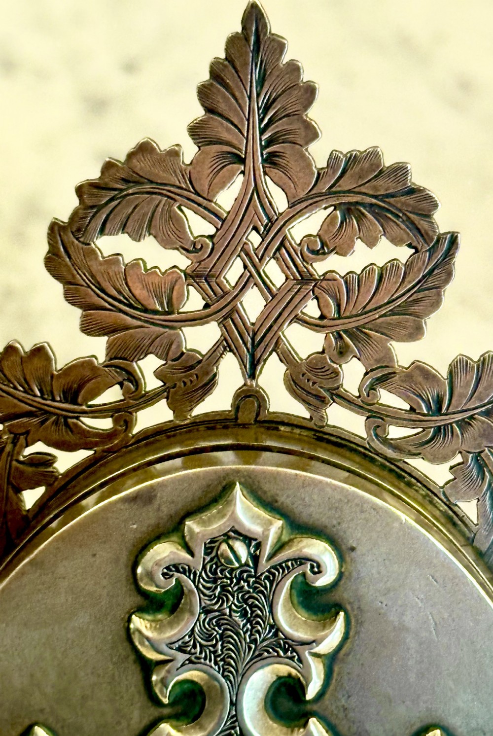An ornate Victorian brass double picture frame featuring two oval apertures framed by detailed foliate metalwork and an easel stand. View VI