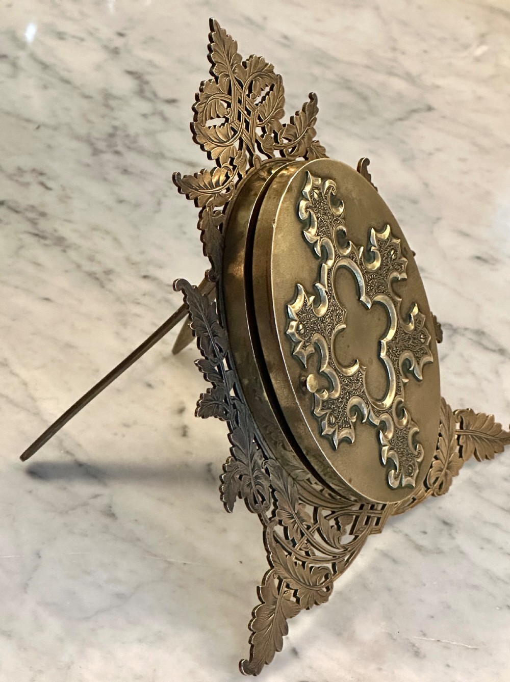An ornate Victorian brass double picture frame featuring two oval apertures framed by detailed foliate metalwork and an easel stand. View VII