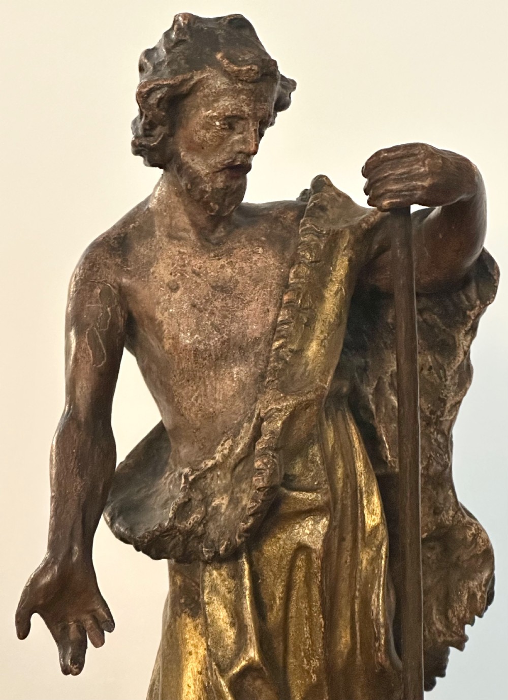 A 17th-century parcel-gilded bronze figure depicting Saint John the Baptist with a staff and lamb, standing on a rectangular wood plinth base. View VI