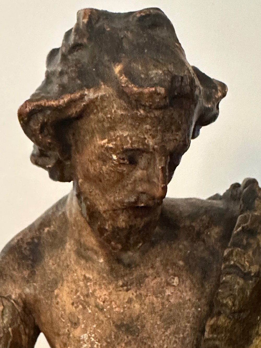 A 17th-century parcel-gilded bronze figure depicting Saint John the Baptist with a staff and lamb, standing on a rectangular wood plinth base. View VIII