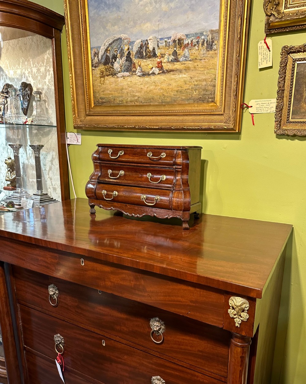 A miniature dark oak Dutch apprentice chest of drawers featuring a bombee front, three drawers with brass drop handles, and carved bracket feet. View VIII
