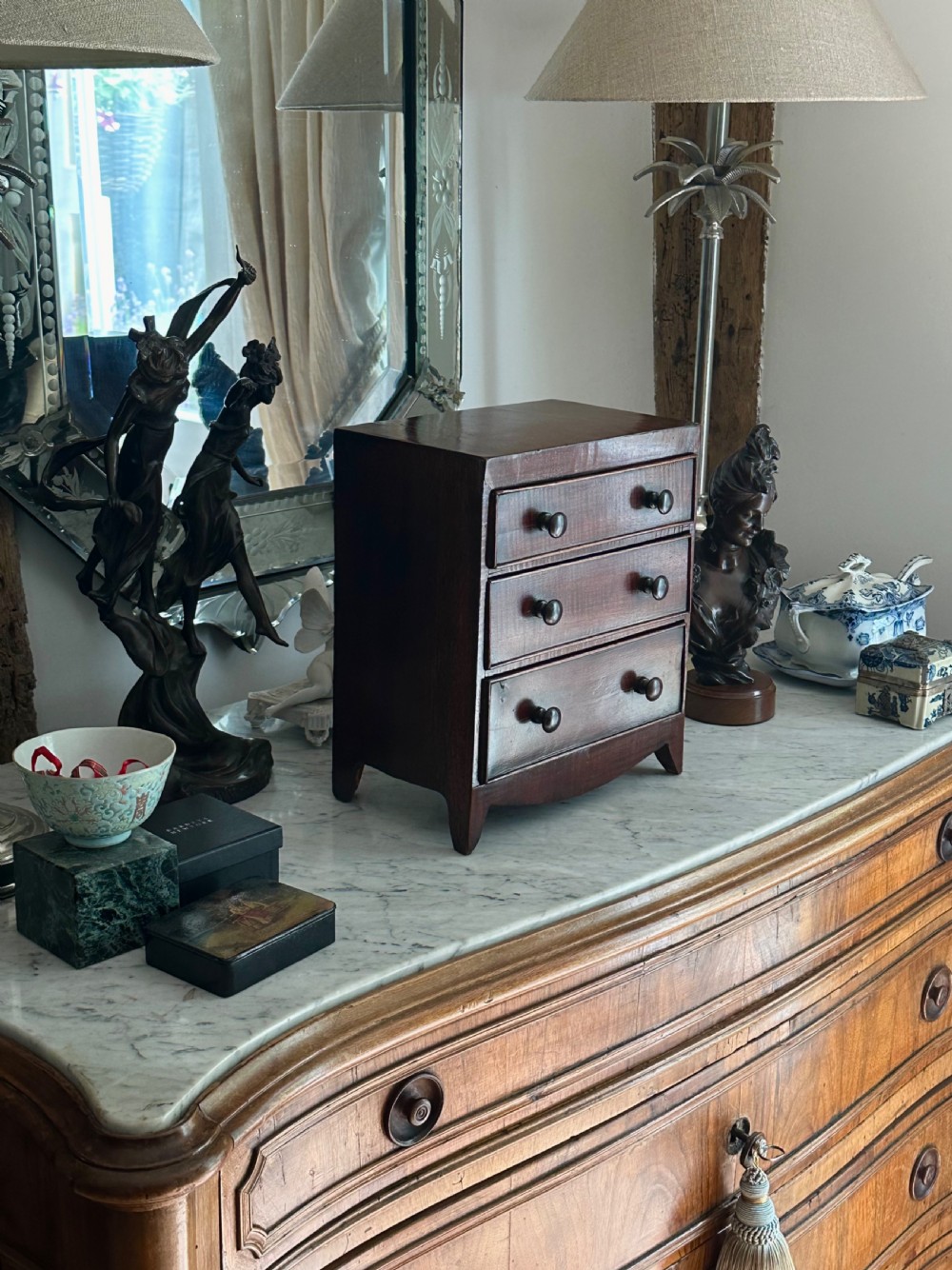 An antique mahogany miniature apprentice chest featuring three drawers with turned knobs and a shaped lower apron. View II